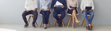 Employees sitting in a row doing a pulse survey
