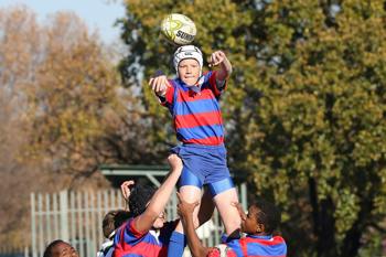 A teenage boy playing rugby at school.