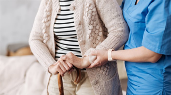 care worker helping an elderly resident walk