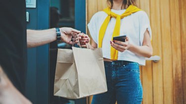 A man handing a bag over to a woman