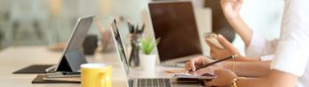 Image of employee using laptop in open concept office