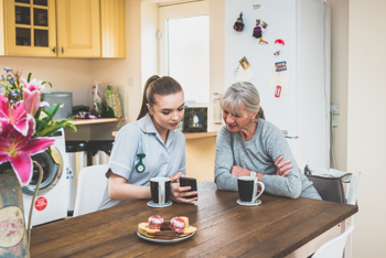 2 ladies looking at care software