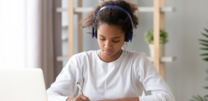 School pupil studying from home with headphones on