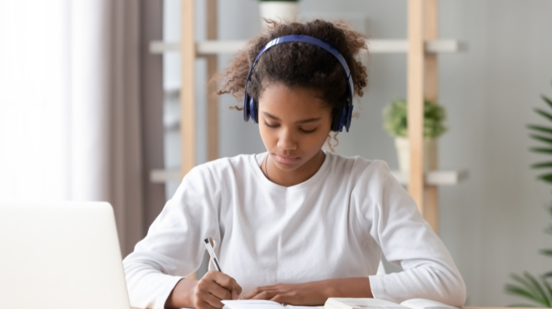 School pupil studying from home with headphones on