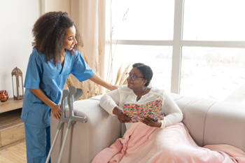 Female carer helping an older female care recipient. 