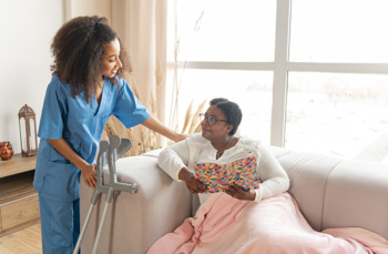 A black woman being comforted by a black female nurse