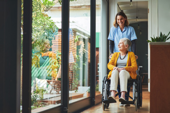 care worker helping an elderly resident in a wheelchair