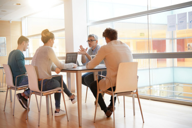 A group of people sitting down discussing 