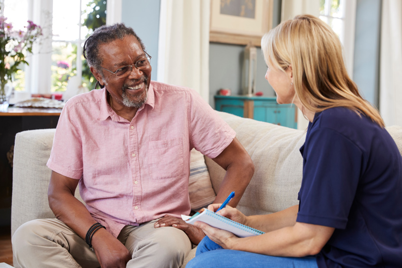 care worker discussing with an elderly man