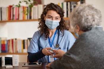 A doctor utilising ambient voice technology to record a patient appointment.