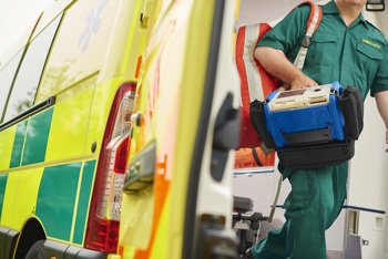 Ambulance crew carrying defib