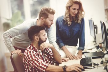 A group of people looking at a computer