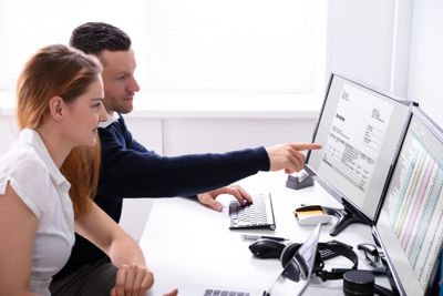 Man and women looking at invoice management software