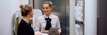 Two Hotel Staff Members Talking In The Linen Storage Room