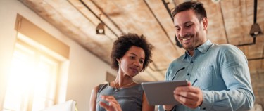 two people talking, one with a tablet
