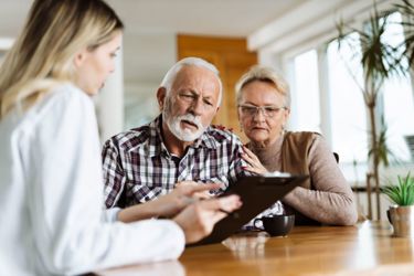A women showing documents to an elderly couple