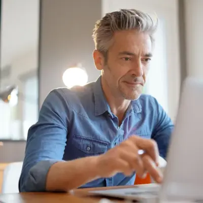 Person working on a laptop at a desk, representing a client sharing their experience with Access Legal software