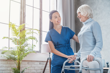 Care worker helping elderly lady not  to fall 