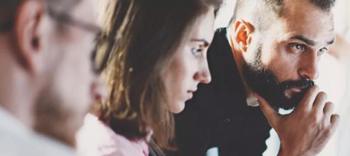 A team of 3 people looking at something together