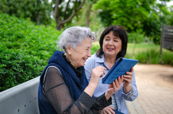 nurse and elderly woman sitting outside