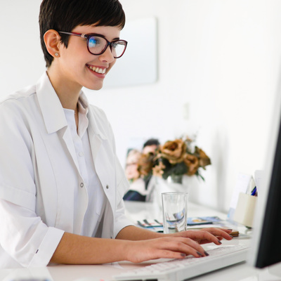 A woman in uniform looking at a computer 