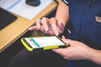 close-up of a care worker checking their work mobile phone