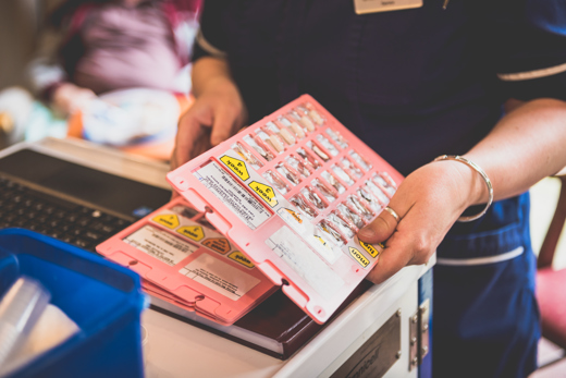 Care planning app with medication management illustrated by a nurse holding medications