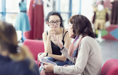 A young woman sitting down with an elderly woman 