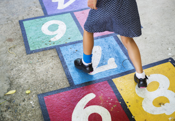 A child playing hopscotch at a volunteer-led youth centre in the community.