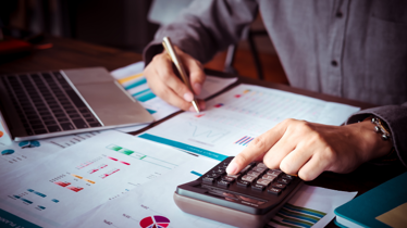 person doing financial calculations on a computer