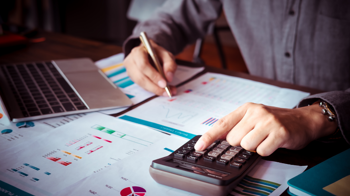 person doing financial calculations on a computer