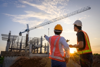 two construction workers looking at a construction site