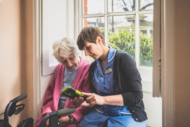 A nurse showing an elderly lady something on a tablet