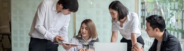Image of employees discussing work in an office