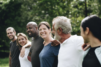 People standing together with their arms around each other smiling 