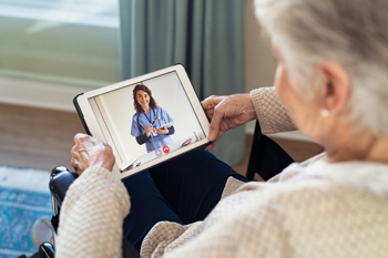 An elderly person using a tablet for professional health advice