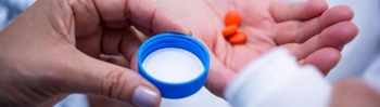 hand holding a several pills