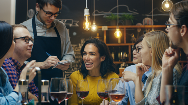 a group of customers enjoying a restaurant served by waiter