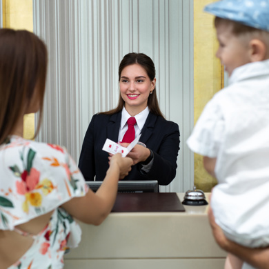 Hotel Staff Handing Key Card To A Family