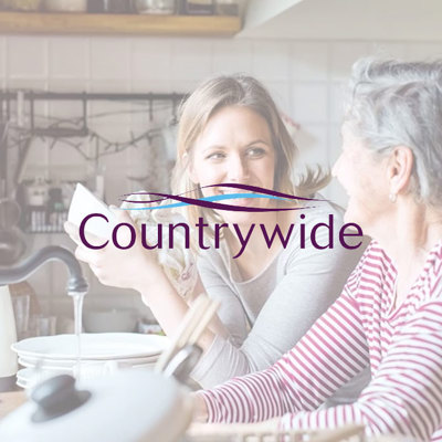 Two women chatting at a kitchen table with dishes, overlaid by the ‘Countrywide’ logo