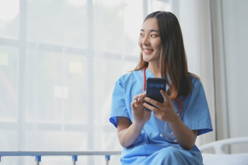 nurse in the bathroom smiling on her phone