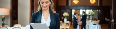 Woman looking at clipboard in hotel dining room
