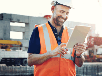 construction worker holding a tablet and smiling