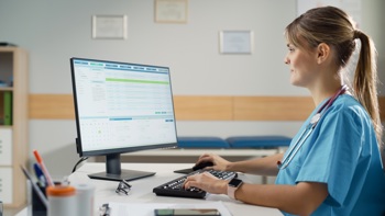 Nurse sat at a desk on a computer