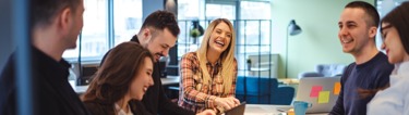 Image of a happy and laughing group of employees in the office