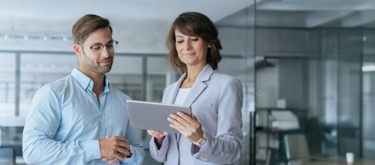 Man and woman in business wear looking at tablet