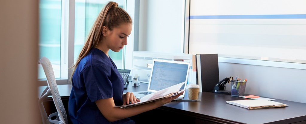 A nurse using healthcare software to collaborate with other clinicians.
