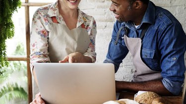 A woman and a man looking at a laptop