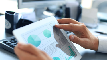 Man using iPad to look at data and analytics