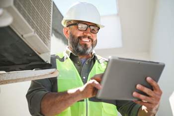 constructor similing and holding a tablet
